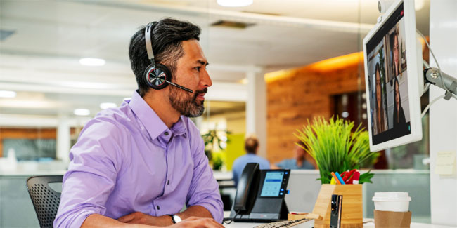 Man in Office Wearing Poly Voyager Focus 2 Headset